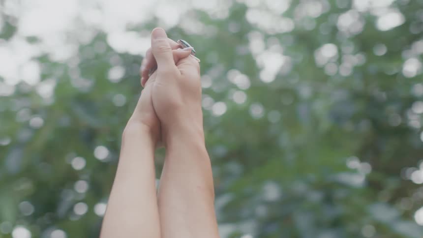 A man and woman raise their hands in the air and play with one anothers fingers and hold hands