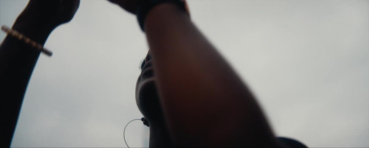 Young woman filming the city skyline with her smartphone on an overcast day