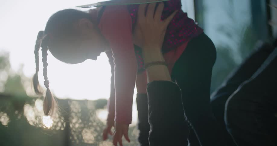 Father and toddler daughter wearing costumes playing over the rug on the living room at morning