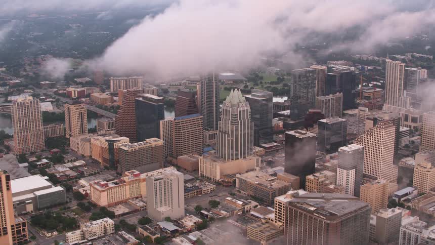Clouds loom over the skyscrapers and buildings in a metropolis during the day