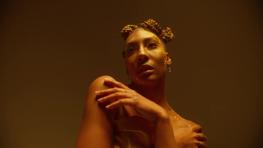 A woman modeling in a room and wearing jewelry