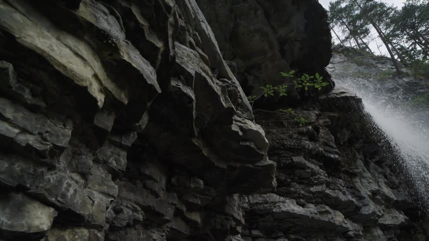 Water flows and splashes over the edge of a rocky ledge