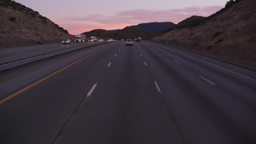 Heavy traffic passes down a highway along a canyon