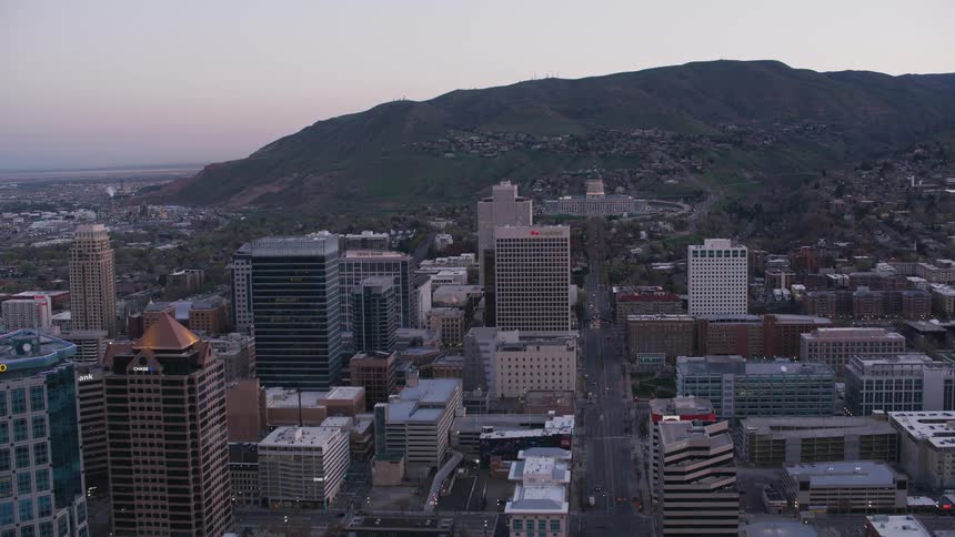 An aerial view of a downtown city at dusk is displayed