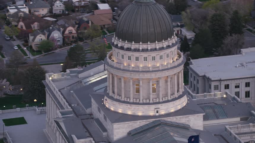 A large domed government building in a town during the evening