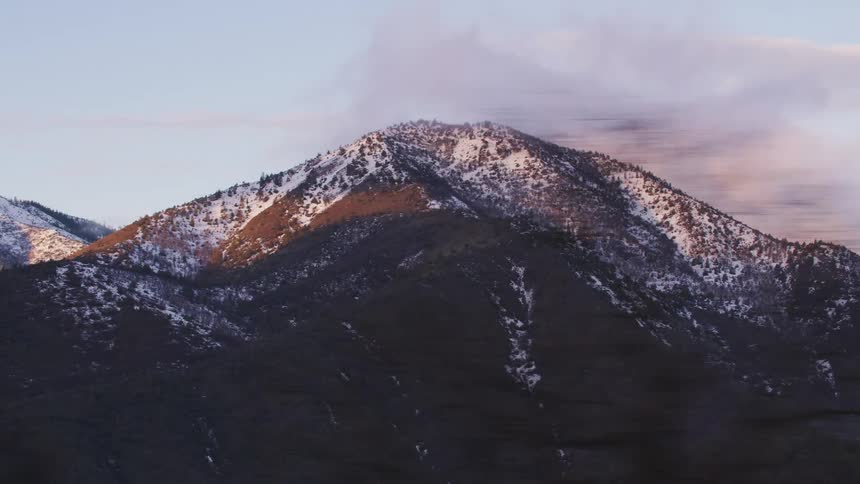 Snow and forest cover mountains undera red tinted clouds