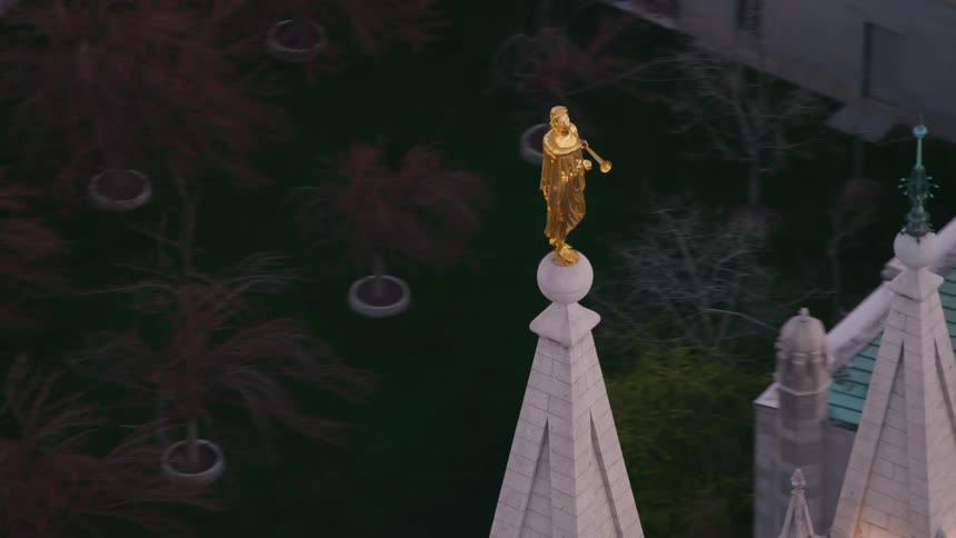 A golden sculpture atop a steeple on a large building