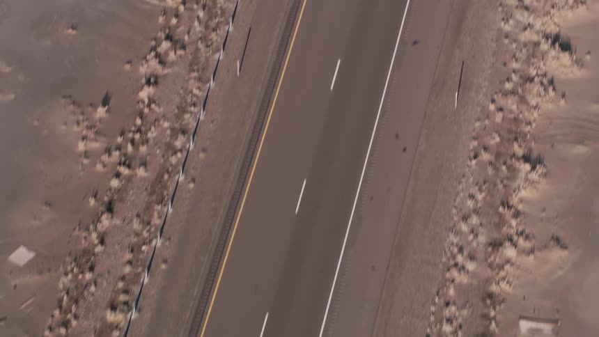An empty highway cutting through salt evaporation ponds