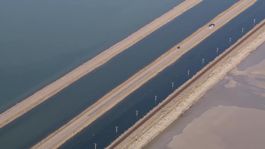 Aerial view of light traffic moving across a bridge over water