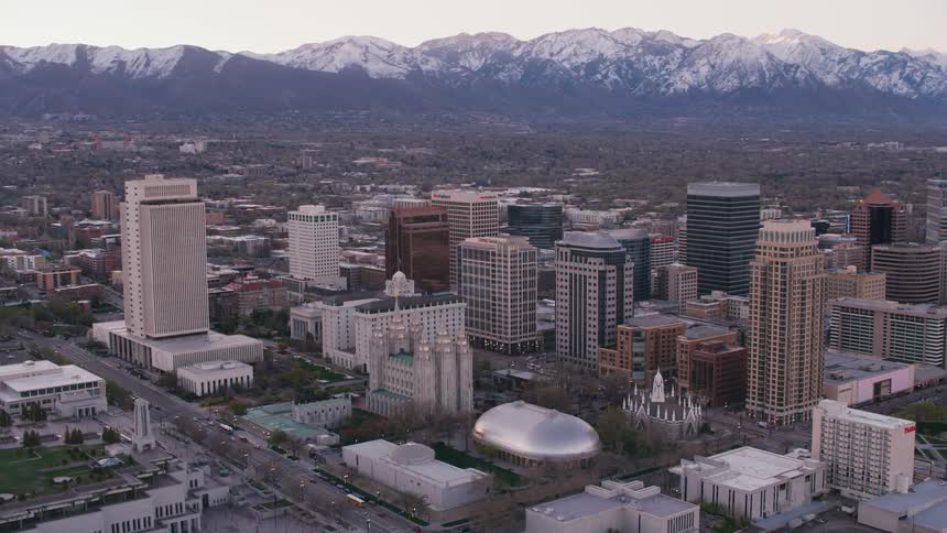 Downtown with tall buildings and skyscrapers and snow covered mountains in the distance