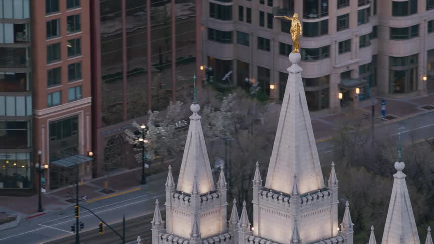 A gold statue is on top of a downtown building