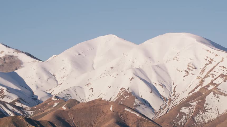 Aerial view of the peaks of a mountain range covered in snow