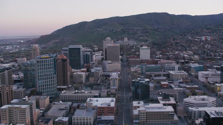 An aerial view of a city with cars driving on streets past high rise office buildings