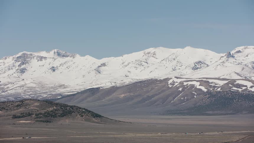 Aerial view of the peaks of a mountain range covered in snow on a deserted area