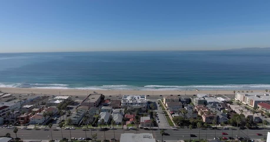 Aerial view of a town with cars driving by a beach