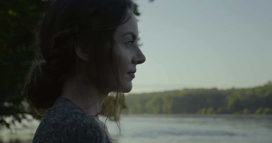 A woman is looking over towards the water