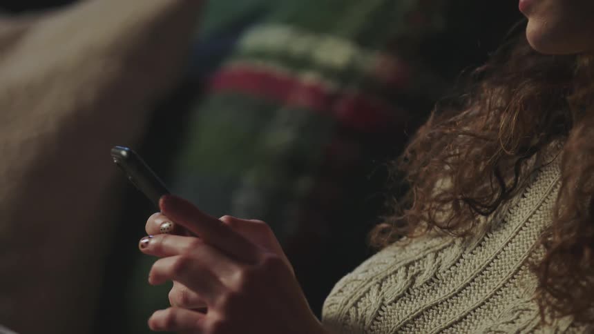 A woman is typing on her cell phone