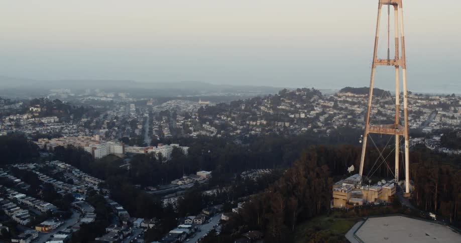 A large antenna is on the hill by the city