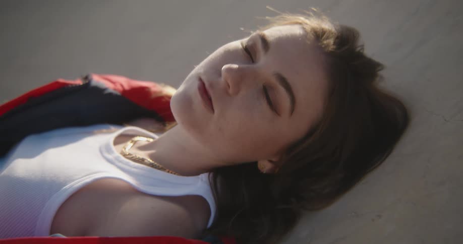 Woman reclines against concrete looking around