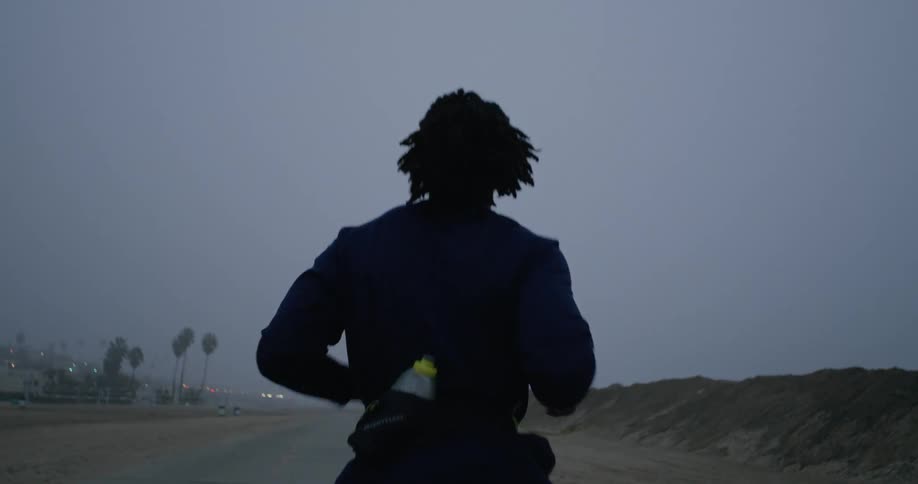 A black man is running on a rural road
