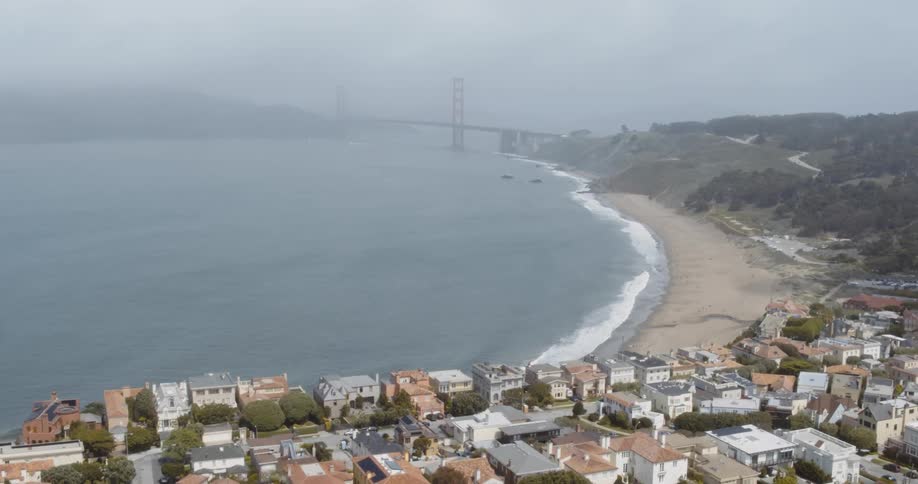 Aerial view of coastal town with bridge in fog