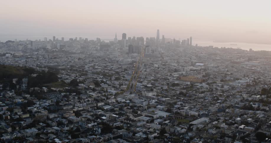 Aerial view of a city with many buildings close together and tall buildings and skyscrapers on the horizon