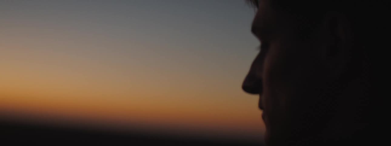 Young man checks his watch at sunset