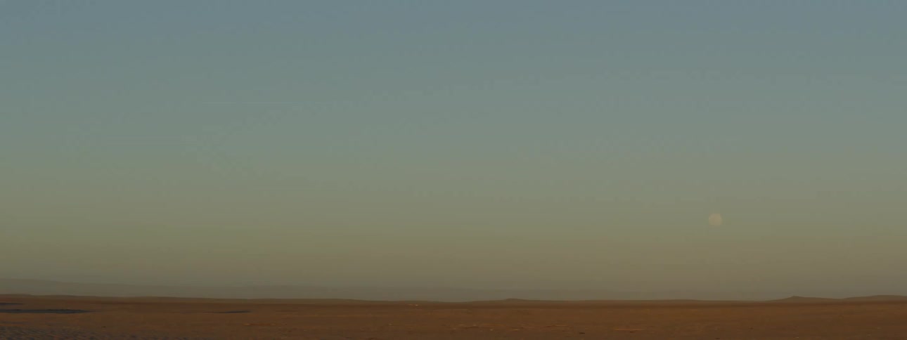 Full moon over the horizon in a desert