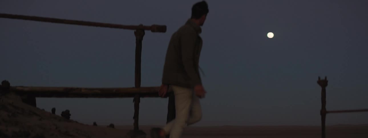Young man walking through the rusted ruins of a shipwreck
