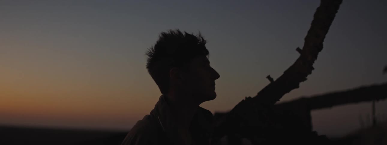 Silhouette of a man standing at sunset on a deserted shipwreck
