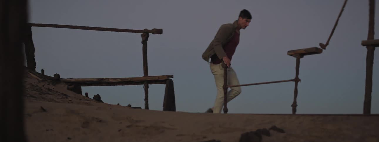 Young man explores a shipwreck in the desert
