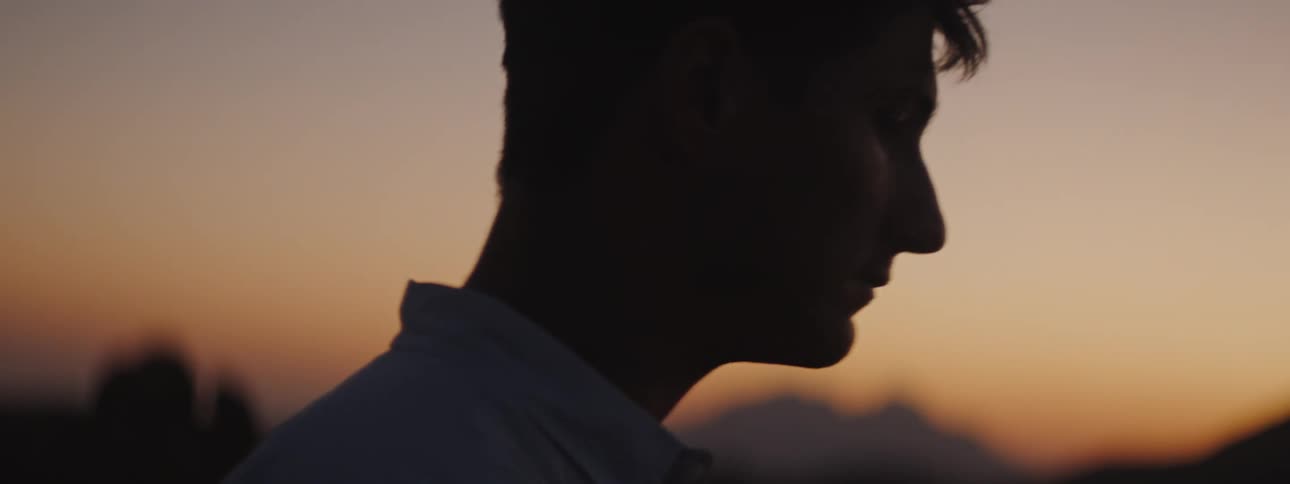 Young man with silhouetted against a night red sky