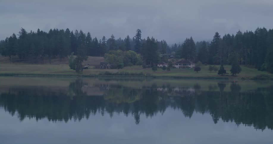 A house in a rural area in front of a lake