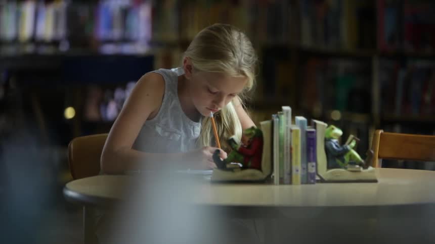 A girl is writing in a notebook