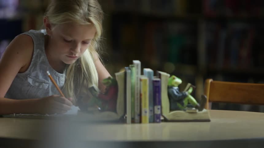 A girl is writing with a pencil