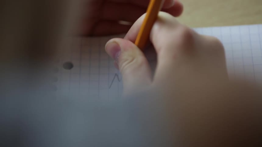 A person is writing in a notebook
