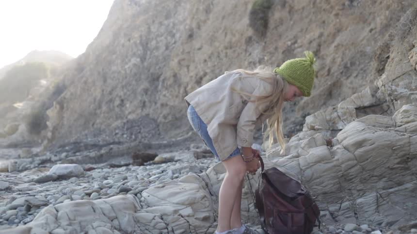 A girl puts on a hat, picks up her backpack and leaves