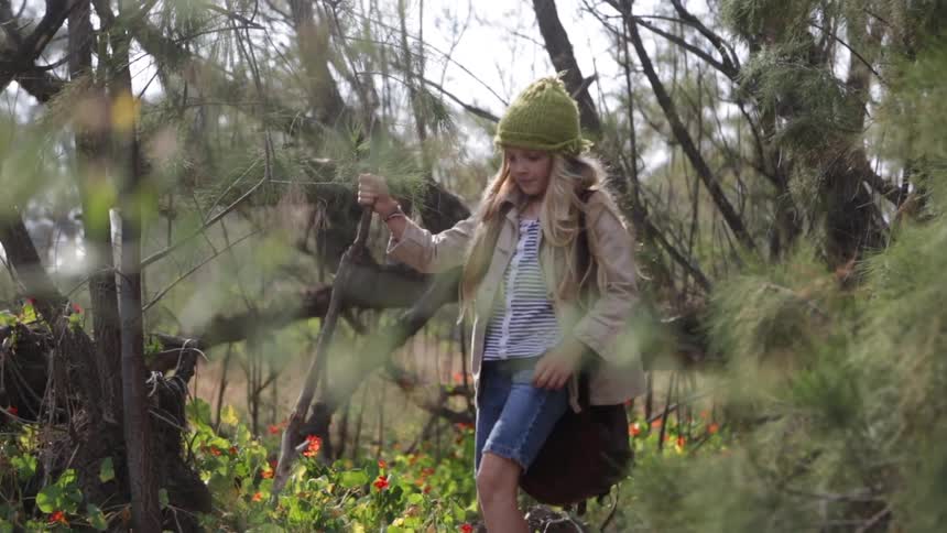 A girl is walking through the woods