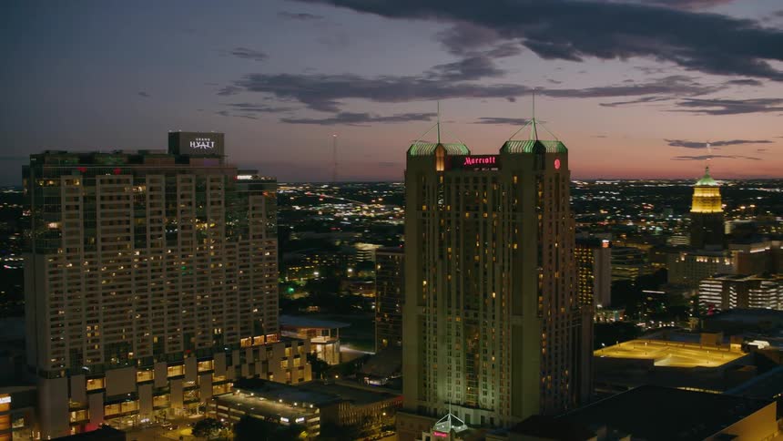 Hotel skyscrapers loom above a bustling city at night