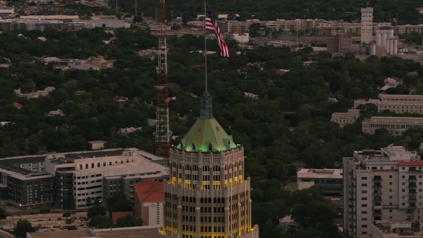 An american flag blows in the wind atop the dome of a downtown building