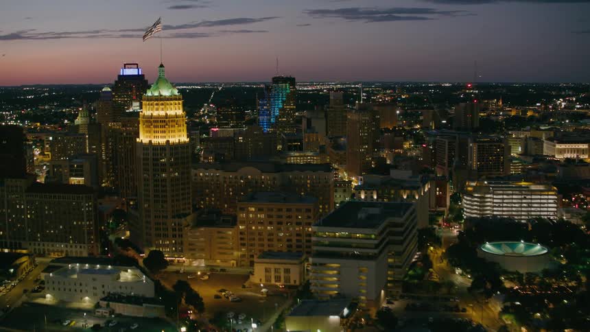 An american flag flies above a lighted dome over downtown