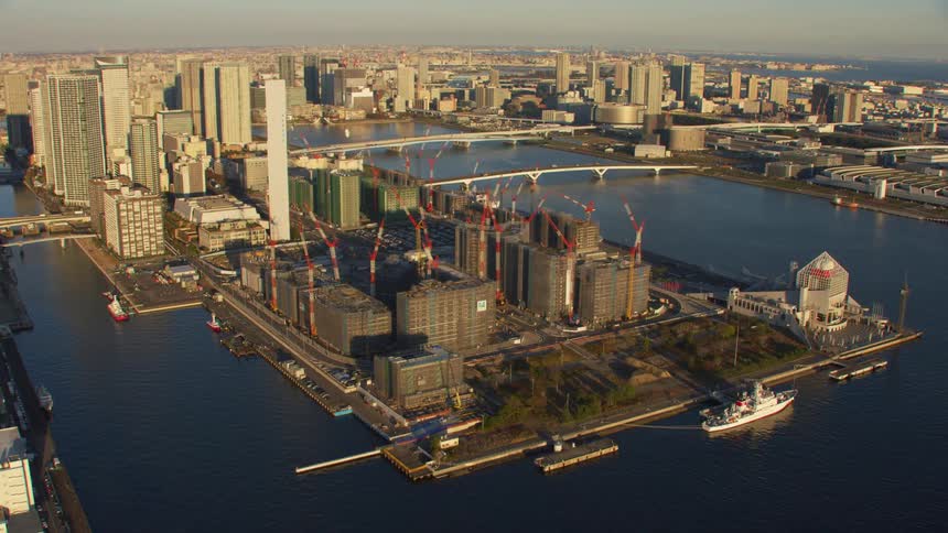 Multiple buildings sit under construction along the coast of downtown
