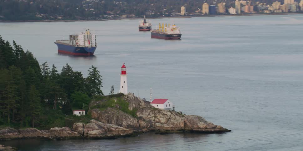 Small homes sit below a lighthouse on a peninsula that faces downtown