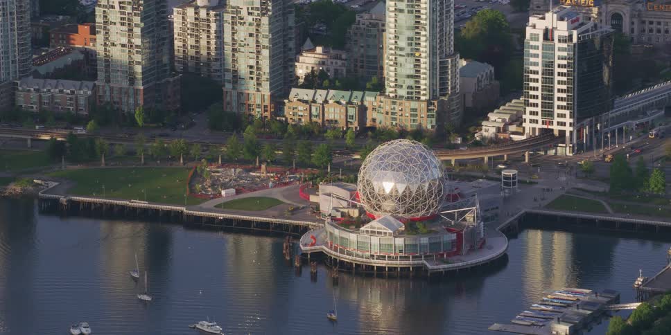 A building with an elaborate sphere atop it is located within a coastal metropolis