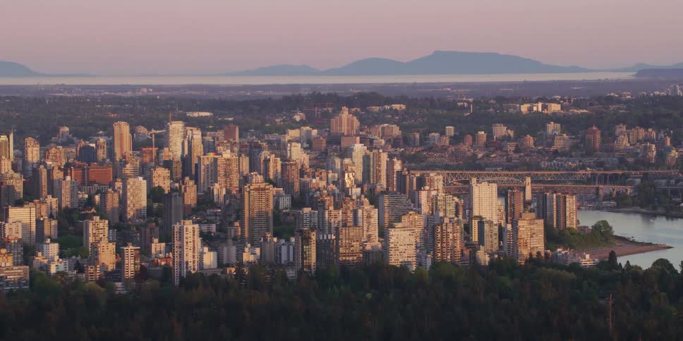 An aerial view of a city skyline by a river with high rise office buildings and apartments