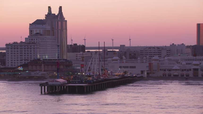 An aerial view of a boardwalk and hotels on the shore