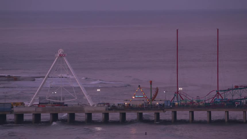 Aerial view of a pier carnival close to the ocean at evening