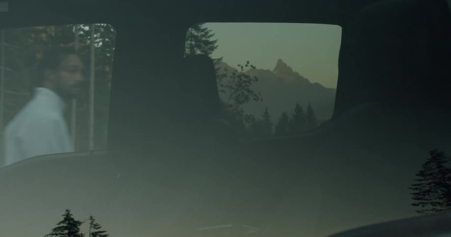 A man is walking by the outside of a parked car