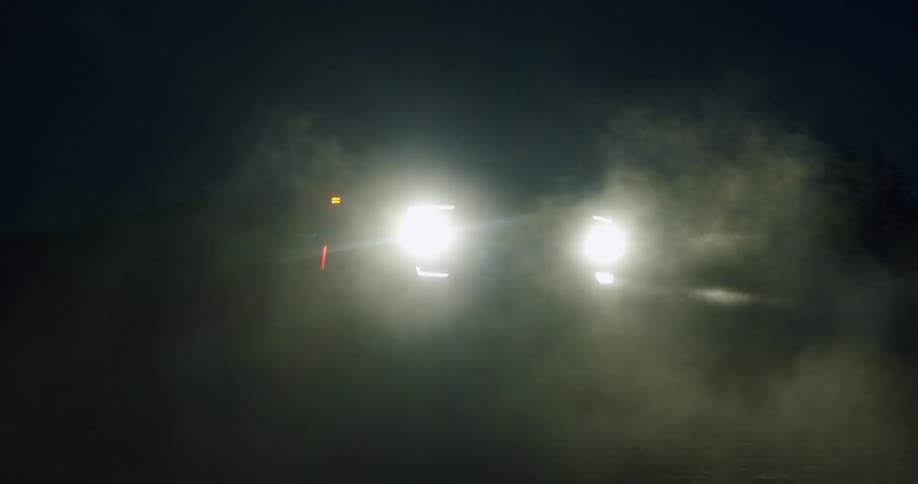A car is parked outdoors at night in a rural area