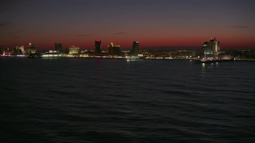 A city along the coast is lit up with bright lights at night